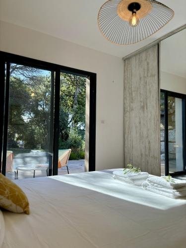 une chambre avec un grand lit avec une grande fenêtre dans l'établissement La Villa Julea, à Olmeto