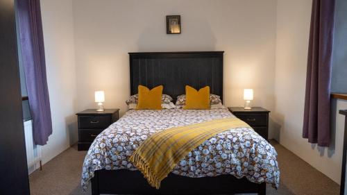 una camera da letto con un letto grande con cuscini gialli di Stable Cottage - Kinbane Self Catering Cottages a Ballintoy