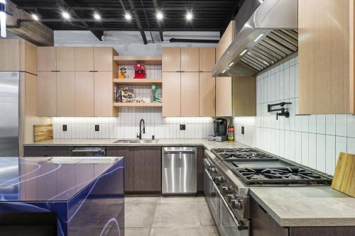 a large kitchen with wooden cabinets and a stove at NEW Luxury Concrete Home Just Minutes from the Beach in Long Beach