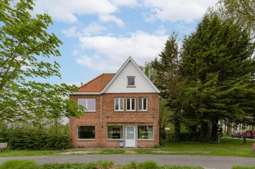 a red brick house with a white door at Huswell - Holiday home along the canal with great views in Damme