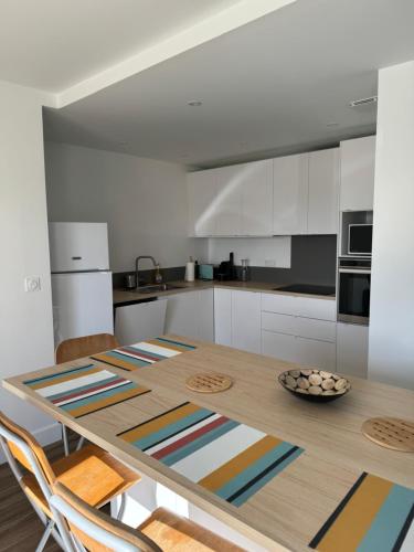 une cuisine avec une table en bois et 2 chaises dans l'établissement Appartement Granville, à Granville