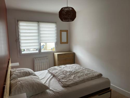 une chambre avec un lit et une fenêtre dans l'établissement Appartement Granville, à Granville