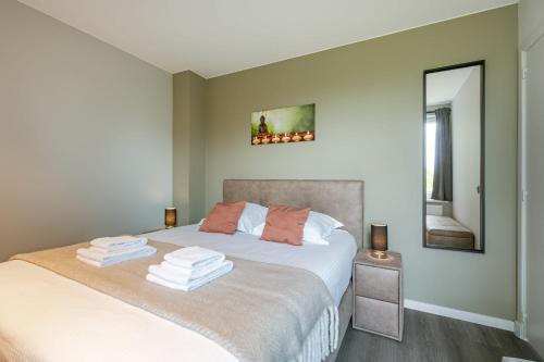 a bedroom with a bed with towels on it at Huswell - Holiday home along the canal with great views in Damme