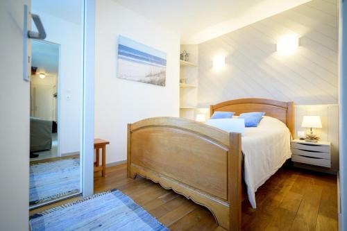 une chambre avec un lit et un miroir dans l'établissement Nice and quiet appartment only 2 steps away from the harbour of St Martin, à Saint-Martin-de-Ré