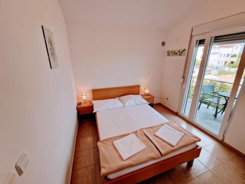 una piccola camera con letto e balcone di Apartmani Villa Medići a Vrsi (Verchè)