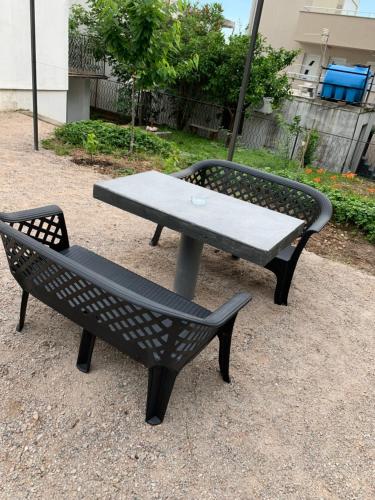 a picnic table and a bench in a park at Mariyka Apartaments 2 in Sutomore