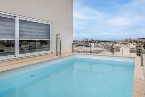 an indoor swimming pool with a view of a city at Luxury Penthouse for families only with Pool and Seaview in Ta Xbiex Malta in Taʼ Xbiex