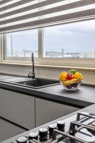 a bowl of fruit sitting on a counter next to a sink at Luxury Penthouse for families only with Pool and Seaview in Ta Xbiex Malta in Taʼ Xbiex