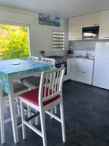 a kitchen with a table and chairs and a refrigerator at Le domaine de Périolat in Le François
