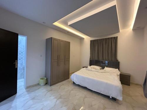 ein Schlafzimmer mit einem großen Bett und einem großen Fenster in der Unterkunft شقق النسيم بلس بالباحة in Al Bahah