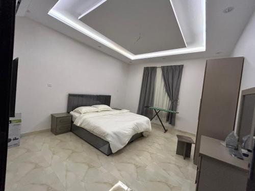 1 dormitorio con 1 cama y tragaluz en شقق النسيم بلس بالباحة, en Al Bahah