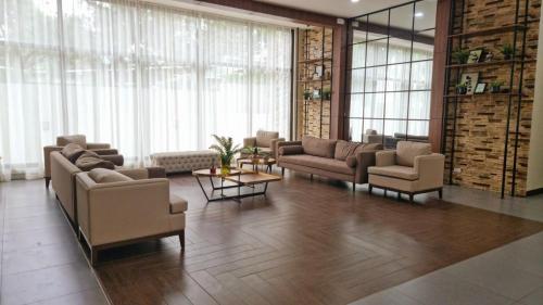 a large living room with couches and tables and windows at CozyNest Rentals at Brenthill Condominium in Baguio