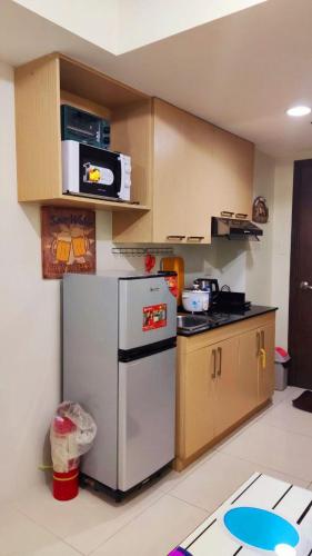 a kitchen with a refrigerator and a microwave at CozyNest Rentals at Brenthill Condominium in Baguio
