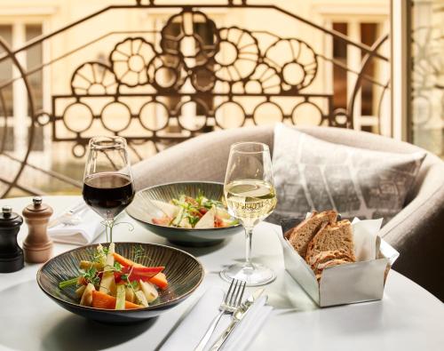 - une table avec deux verres de vin et une assiette de nourriture dans l'établissement Sofitel Paris Arc De Triomphe, à Paris