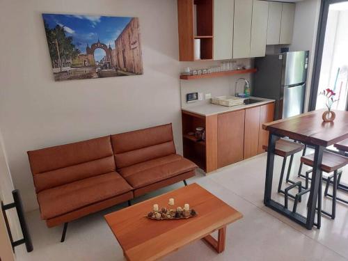 a living room with a couch and a table and a kitchen at TIKUL EN Merida HISTORIC CENTER in Mérida
