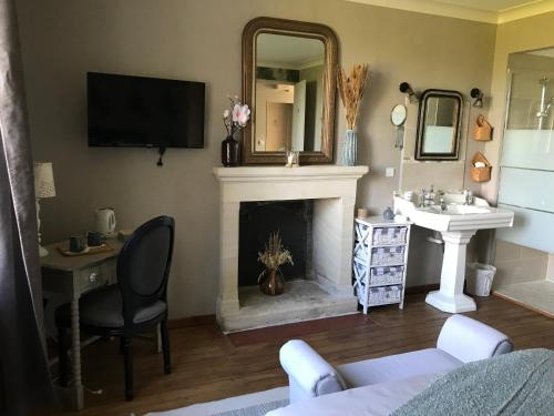 - un salon avec une cheminée et un lavabo dans l'établissement Chambres d'hôtes de la baie, à Sallenelles