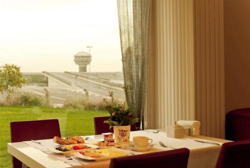a table with food on it with a view of an airport at Orty Airport Hotel in Izmir