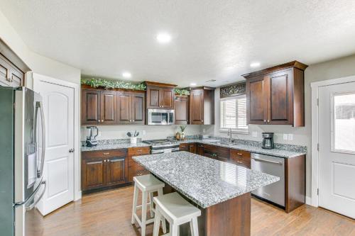 a kitchen with wooden cabinets and a granite counter top at Utah Retreat with Patio, Gas Grill and Mountain Views! in Logan
