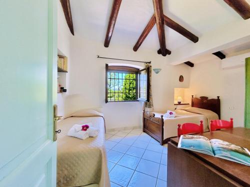 Habitación con 2 camas, escritorio y ventana. en Villa Palma, en Baja Sardinia