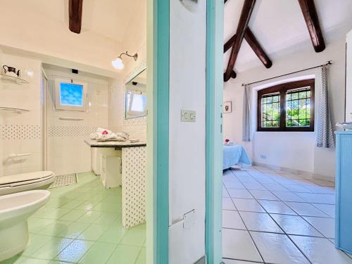 y baño con aseo y lavamanos. en Villa Palma, en Baja Sardinia