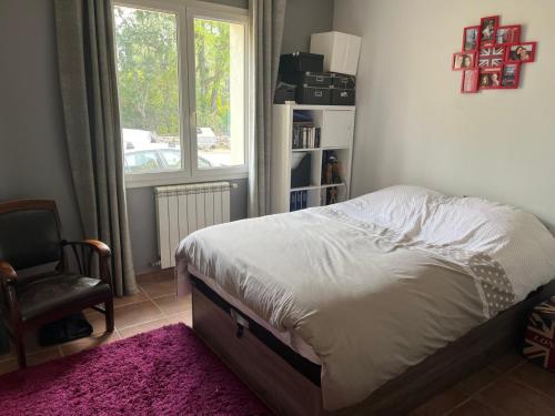 une chambre avec un lit, une chaise et une fenêtre dans l'établissement Villa Jasmin, à Flayosc