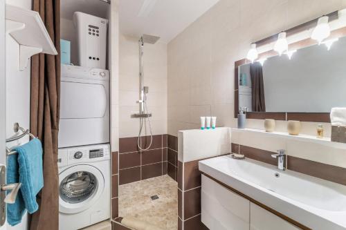 a bathroom with a washing machine and a sink at Vue imprenable sur le lagon, appartement 1ch 4p in Baie Nettle