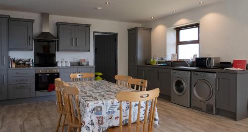 a kitchen with a table and chairs in a kitchen at Kinbane Self Catering Cottages - 'Makem's Cottage' in Ballycastle