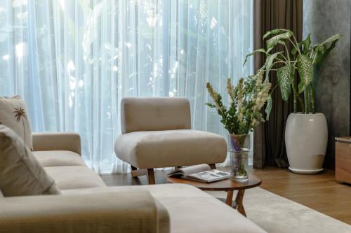 a living room with a couch and a chair and a table at Sunny Cuddles in Canggu