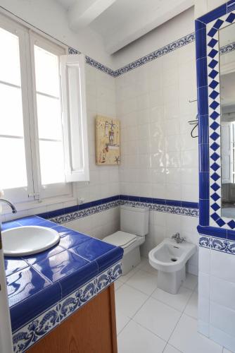 a blue and white bathroom with a sink and a toilet at Vila d'Alba in Sant Andreu de Llavaneres