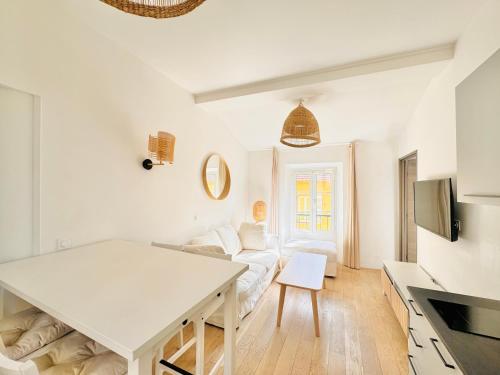 un salon blanc avec une table et un canapé dans l'établissement Le Bohème - Logement Cozy centre, à Cannes