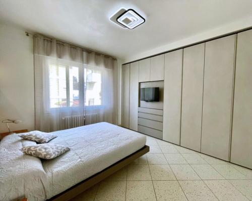 a bedroom with a bed and a tv and a window at Venice Travel Dream Spacious Apartment near Venice in Mestre