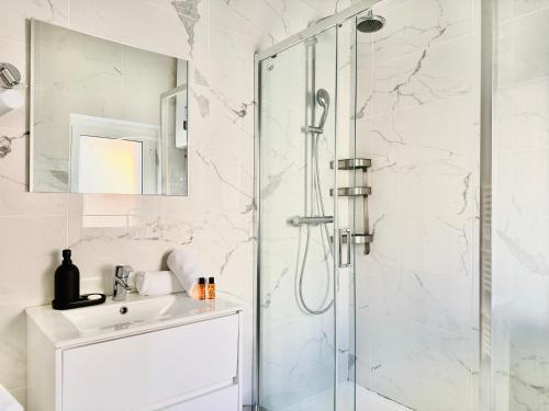 une salle de bain blanche avec une douche et un lavabo dans l'établissement Le Bohème - Logement Cozy centre, à Cannes