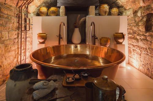 une grande baignoire en cuivre dans une pièce avec vases dans l'établissement No 15 by GuestHouse, Bath, à Bath