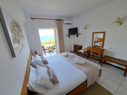 a bedroom with a bed with a view of the ocean at 75 Steps Apartments in Mesongi