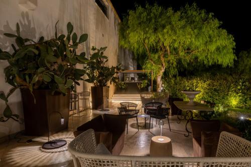 a patio with chairs and plants at night at Villa Favorita Hotel & Events in Marsala