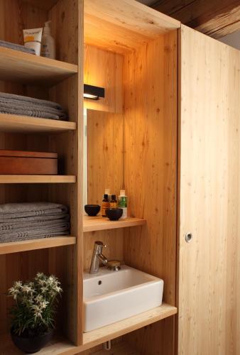 a bathroom with a sink and wooden walls at Montagne Alternative in Orsières