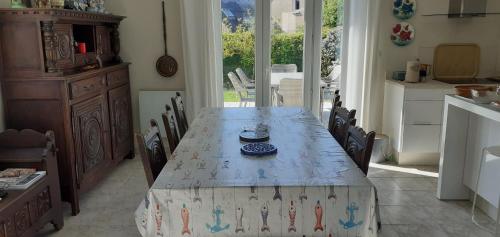 une table dans une cuisine avec un chiffon de table dans l'établissement Résidence 250 m plage de Guidel, à Guidel