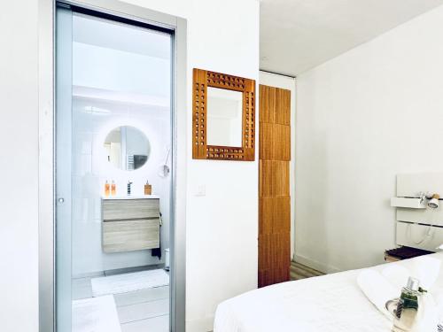 - une chambre avec une porte en verre menant à une salle de bains dans l'établissement L’éclat - Appartement terrasse - Centre Cannes, à Cannes