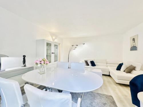 un salon blanc avec une table et des chaises blanches dans l'établissement L’éclat - Appartement terrasse - Centre Cannes, à Cannes