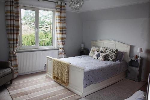 1 dormitorio con cama blanca y ventana en Lovely 3 bed condo en Reigate