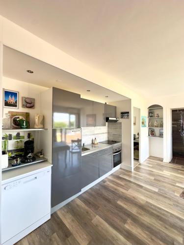 - une grande cuisine avec des appareils en acier inoxydable et du parquet dans l'établissement Appart 2 pièces 45m2 Cavalaire/Mer, à Cavalaire-sur-Mer