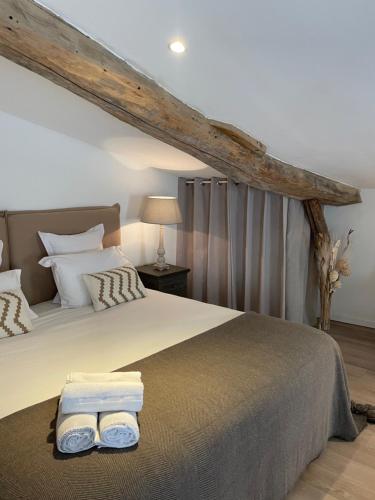 a bedroom with a bed with two towels on it at La Maison du Clocher in Saint-Émilion