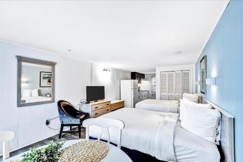 a hotel room with two beds and a desk at Ocean Breeze Motel in South Yarmouth