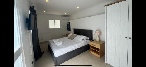 a small bedroom with a bed and a night stand at Suite 10 at Palazzo Seraphim Boutique living in St Julians in St Julian's