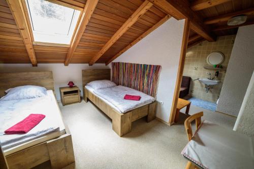 a bedroom with two beds and a sink in a room at Pension Arberwald in Bayerisch Eisenstein