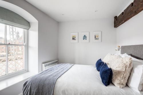 a white bedroom with a bed and a window at Luxury Apartment Woodsmill View - on the river - with balcony - Recently refurbished in York