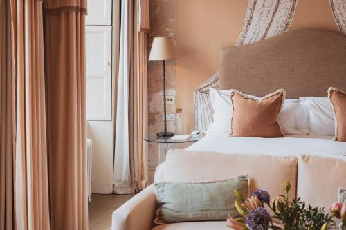 No 15 by GuestHouse, Bath في باث: غرفة نوم بسرير واريكة عليها ورد