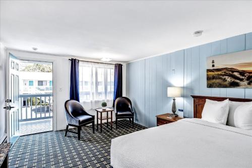 a hotel room with a bed and a table and chairs at Ocean Breeze Motel in South Yarmouth