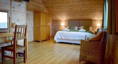 ein Schlafzimmer mit einem Bett in einer Holzhütte in der Unterkunft Coll Lodge, Isle of Harris in Manish