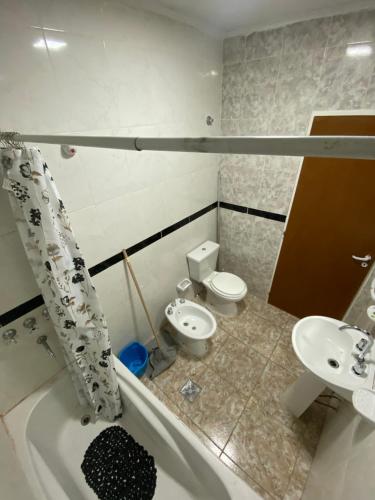 a bathroom with a tub and a toilet and a sink at Departamento la terminal in General Roca